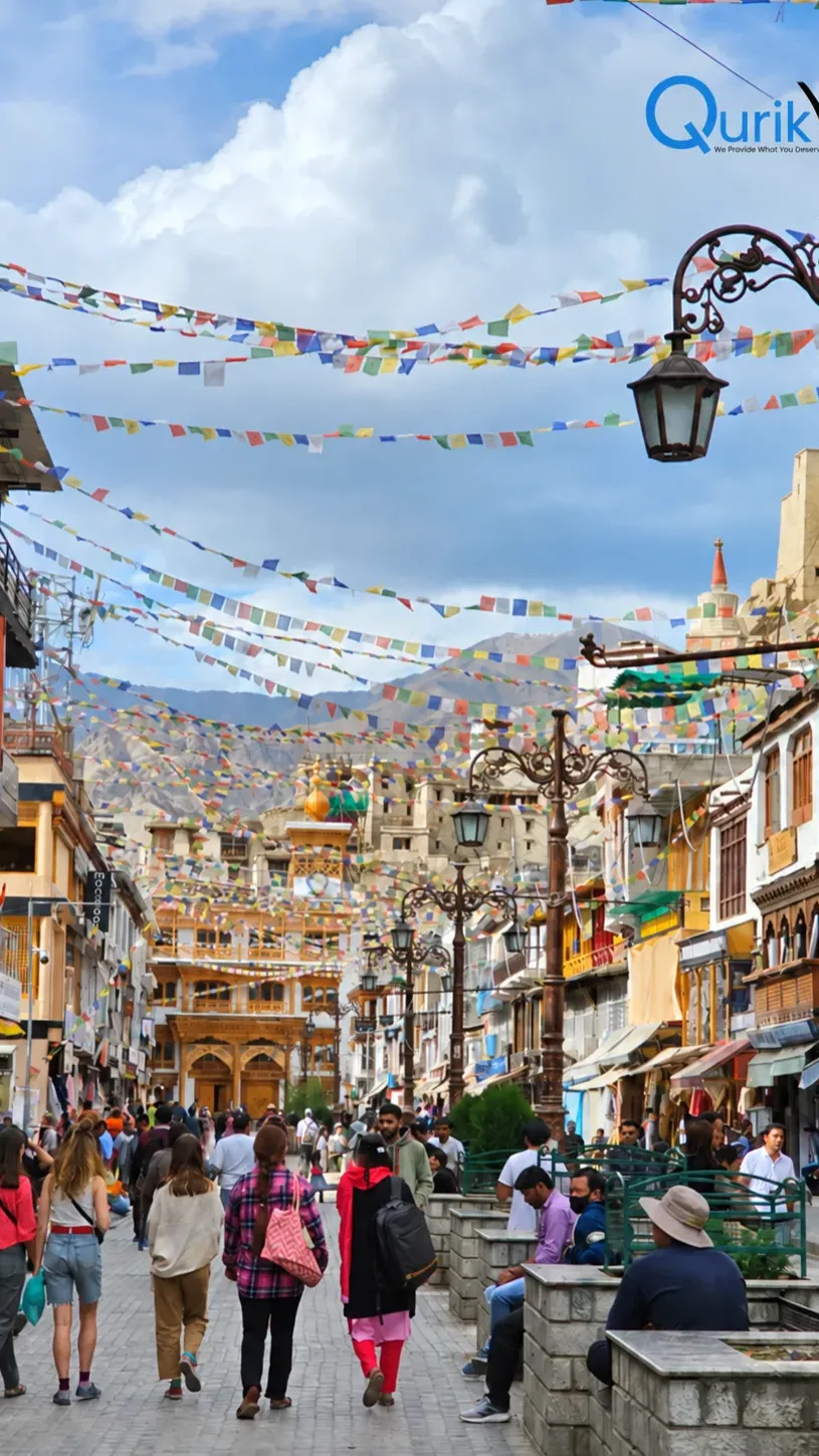 Busy Leh market street decorated with colorful Tibetan prayer flags and local shops